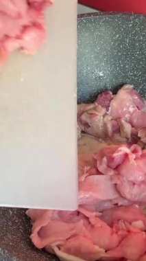 Kızartma tavasında et parçaları. Kızartma tavasındaki et, ahşap bir spatulayla karıştırılır. Et kendi suyunda kaynıyor. Kızartma tavasında et parçaları