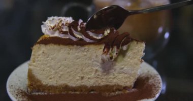 Tahta arka planda bir kaşık karamelli cheesecake, üst manzara. New York peynirli keki, kopyalama alanı. Kaşıkla yaban mersinli kek yiyen kadın.