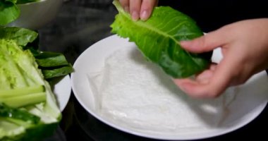 Pişirme işlemi kağıt, salata, salatalık, domuz yağı, kadın eli, beyaz tabak, doğu yemekleri, adım adım pişiyor.