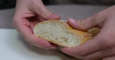 Peynir için dilimlenmiş Fransız ekmeği dilimliyorum. Mutfaktaki Ekmek 'i kesiyorum. Sabah Kahvaltısı hazırlıyorum. Masada taze ekmek var. Fransız ekmeği kesiyorum. Pandispanya için buğday ekmeği.