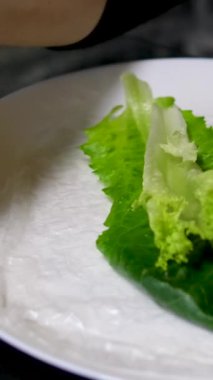 Pişirme işlemi kağıt, salata, salatalık, domuz yağı, kadın eli, beyaz tabak, doğu yemekleri, adım adım pişiyor.