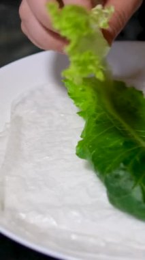 Pişirme işlemi kağıt, salata, salatalık, domuz yağı, kadın eli, beyaz tabak, doğu yemekleri, adım adım pişiyor.