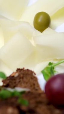 Çeri domatesli, üzümlü ve zeytinli dilimler halinde peyniri dilimleyin. Restoranda peynir servisi.