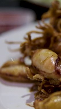 Kızarmış ahtapot. Izgara ahtapotun birinci şahıs görüntüsü geliyor. Bir parça barbekü sosunu sarı sosa batırmak. Plaj restoranında lezzetli deniz ürünleri yemek. Bali gurmesi.