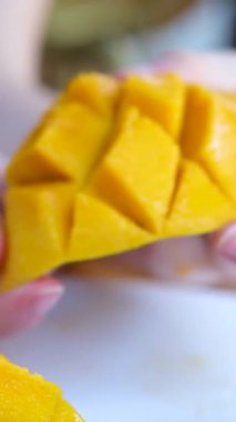 Kız mango kesiyor, lezzetli sulu olgun mango kesiyor bıçakla küp küp kesiyor. Tropik meyve. Mango video eğitiminin nasıl kesileceğini. sağlıklı konsept yemek. Mango Makro kamera hareket ediyor