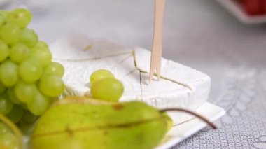 Krem peynirli peynir ve bir restoranda balla servis edilen üzümler. Ahşap şişler lezzetlidir. pahalı