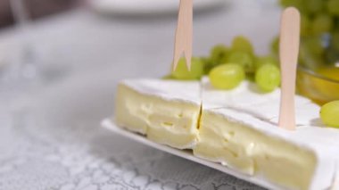 Krem peynirli peynir ve bir restoranda balla servis edilen üzümler. Ahşap şişler lezzetlidir. pahalı