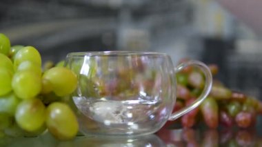 Üzüm damlası köpüklü tableti bir bardak su tabletine damlatıp bir bardak suda eritiyor. Fizzy hapı bir bardak suyun içinde. Ağrı kesici. İçecek, sağlık, sağlık, su, vitamin, tedavi kavramı