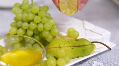 Meyve yememek için üzüm, bal armudu ve peynir tabağı. Üzerine limon suyu serp.