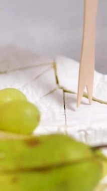 Krem peynirli peynir ve bir restoranda balla servis edilen üzümler. Ahşap şişler lezzetlidir. pahalı