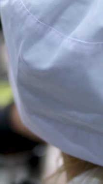 Küçük kız aşçı beyaz şapkalı ve önlüklü bir kızı mutfakta sırt üstü pişirmeyi öğreniyor. İnsanlar et pişirir, anne kızına öğretir.