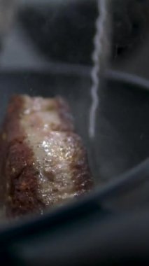 Kızartma tavasına biftek olarak ezilmiş sarımsak ve kekik ekliyorum. Kızartma tavasında et kızart
