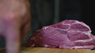 Baharatlı biftek pişirme süreci ve ahşap mutfak masasında otlar, üzerine deniz tuzu ve biber serpiştirme süreci. Adım adım, bir adam biftekleri doğruyor ve kızartma tavasında kızartıyor.