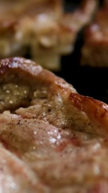 Baharatlı biftek pişirme süreci ve ahşap mutfak masasında otlar, üzerine deniz tuzu ve biber serpiştirme süreci. Adım adım, bir adam biftekleri doğruyor ve kızartma tavasında kızartıyor.