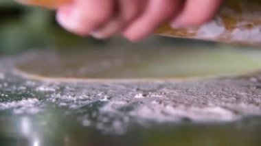 Geleneksel Türk baklava hamur işi pişirme süreci. Tanımlanamayan şef, hindistancevizli tatlı baklavası için ince filo hamuru yapıyor. Hamuru ince bir tabaka haline getir. 