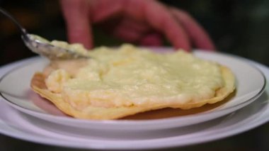 Tanımlanamayan pasta şefi katmanlı kremalı pasta hazırlıyor. Pastaya krema sür.