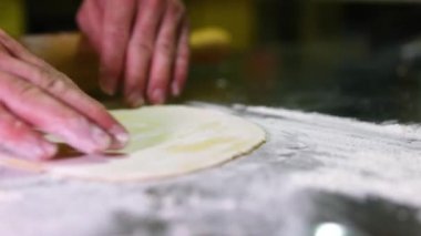 Adım adım kruvasan hazırlama süreci. Un, yumurta, tereyağı, süt, şeker ve hamur karıştırıcının eklenmesinden başlayarak, ince bir şekilde sunuluyor. Lastik kapladıktan sonra, hamur soğuyor. Tepside bir sürü kruvasan var. 4k