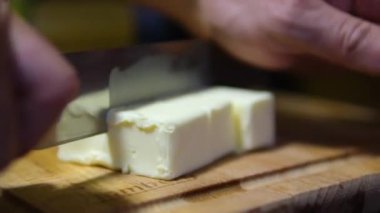 Tereyağı dilimleri bir tabağa konur, kek pişirmek için tereyağını küp şeklinde keser, Tahta üzerinde Taze Tereyağı 'nın Tüm Parçaları, Yakın plan, Makro ve Döndürme. Doğal Tereyağı Çubuklarının İzole Arkaplanı.