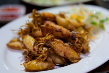 Kızarmış ahtapot. Izgara ahtapotun birinci şahıs görüntüsü geliyor. Bir parça barbekü sosunu sarı sosa batırmak. Plaj restoranında lezzetli deniz ürünleri yemek. Bali gurmesi.