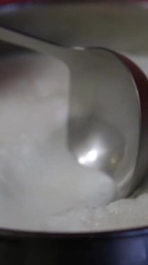 Süt kaynıyor, buhar çıkıyor. Paslanmaz çelik bir kapta süt kaynatmak. Süt kaynamak üzere. Kaynayan süt tavadan gaz sobasına akar. Su ısıtıcısında süt sağılmış inekler. 4K