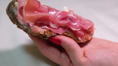 Prosciutto sandviçi jamon ekmekli siyah ekmek krem peynirli kadın eli lezzetli çerez 