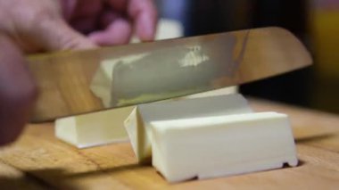 Siyah eldivenli şef salata için tereyağı keser. Kes tereyağını