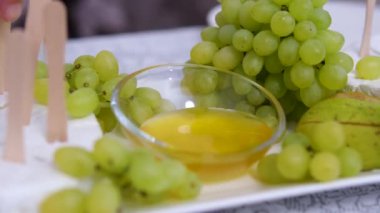 Peynirli Bal ve Üzüm. Adam bal ve üzümlü peynir tadıyor. Gurme aperatifler ya da atıştırmalıklar, antipasto, antipasti. Üzüm peyniri tatlım.