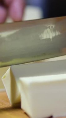 Siyah eldivenli şef salata için tereyağı keser. Kes tereyağını