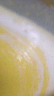 Aşçı, cam kasede kaymak karışımını karıştırmak için kaşık kullanır.