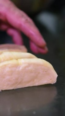 Hamur parçaları ev yapımı ekmek pişiriyor. Turta pişirme işlemi. Elleri mutfak masasına hamur vuruyor. Ekmek için hamuru kesiyorum. Film tanecikleri piksel dokusu. Yumuşak odaklanma. Bulanık. canlı kamera.