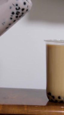 Bardakta muhallebi incili sütlü çay, gri arka plan. Köpüklü çay içeceği.
