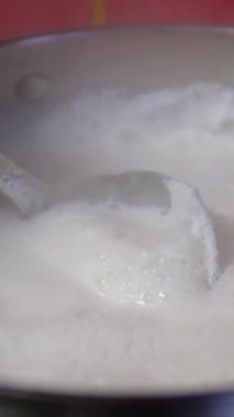 Süt kaynadı ve tavadan gaz sobasına doğru aktı. İnekler sütü bir tencerede kaynatır ve dışarı akar. Süt kaçtı. kaynatılmış süt 