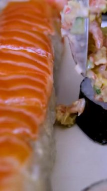 Erkek aşçılar eldiven takmış, aynalı masaya suşi koyuyorlar. Geleneksel Japon mutfağı. İç mekanda lezzetli suşi servisi yapan şefin yakın çekimi. Suşi yap.