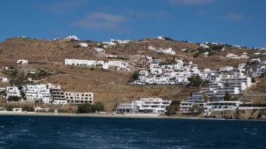 Meşhur yel değirmenleriyle Mykonos kasabası manzarası ve yaz günü tekneleri ve yolcu gemisi olan liman manzarası. Mykonos, Cyclades adaları, Yunanistan. Kamera tavasıyla