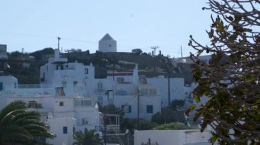 Meşhur yel değirmenleriyle Mykonos kasabası manzarası ve yaz günü tekneleri ve yolcu gemisi olan liman manzarası. Mykonos, Cyclades adaları, Yunanistan. Kamera tavasıyla