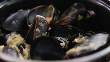 Krema soslu midyeli tencere ve sarımsak ve baharatlı lezzetli ekmek. Lokanta masası. 