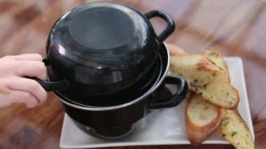 Krema soslu midyeli tencere ve sarımsak ve baharatlı lezzetli ekmek. Lokanta masası. 