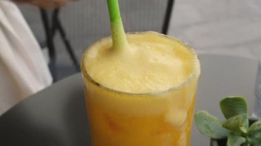 Bardağın üstüne portakal suyu dökülmüş, portakal dilimleri meyve suyu bardağının yanında, üst tarafta. Ağır çekim, kapat.