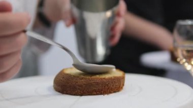 Kadın elleri pembe kremayı güzel bir pembe pastadaki spatulayla aynı seviyeye getiriyor. Kürsüdeki bir kız için doğum günü pastası. Pembe pasta yapan kız.