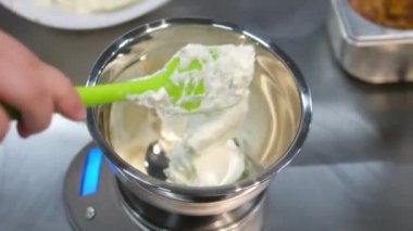 Kadın elleri pembe kremayı güzel bir pembe pastadaki spatulayla aynı seviyeye getiriyor. Kürsüdeki bir kız için doğum günü pastası. Pembe pasta yapan kız.