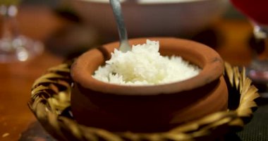 Sıcak beyaz pilav buhar kasesi mutfak arka planı karışık ahşap kaşık. Pişirdikten sonra yapışkan pirinç. Asya Çin Tayland ve Japonya Hindistan. Suşi nefis geleneksel vejetaryen yemekleri yapar.