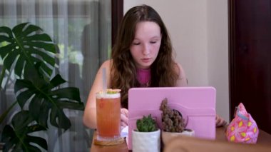 Oturma odasındaki kanepede uzanmış beyaz bir kadın boş vakit geçirmek için film ya da televizyon dizisi arıyor. İspanyol kız internetten film izlemeyi seçiyor. Omuz manzarasının üstünde.