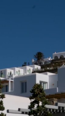 Meşhur yel değirmenleriyle Mykonos kasabası manzarası ve yaz günü tekneleri ve yolcu gemisi olan liman manzarası. Mykonos, Cyclades adaları, Yunanistan. Kamera tavasıyla