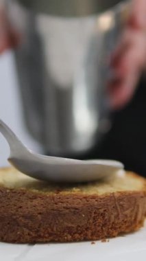 Kadın elleri pembe kremayı güzel bir pembe pastadaki spatulayla aynı seviyeye getiriyor. Kürsüdeki bir kız için doğum günü pastası. Pembe pasta yapan kız.
