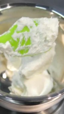 Kadın elleri pembe kremayı güzel bir pembe pastadaki spatulayla aynı seviyeye getiriyor. Kürsüdeki bir kız için doğum günü pastası. Pembe pasta yapan kız.