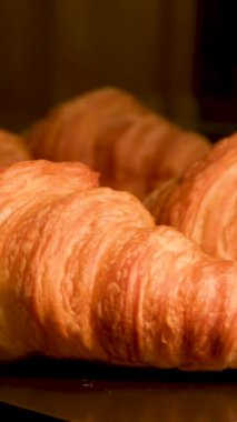 Üzerinde taş mermer masa pişirme çarşafı üzerinde yeni pişmiş altı kruvasan kamera France Hand 'de kahvaltıdan yavaşça uzaklaşır ve pişirme çarşafından taze Fransız kruvasanı alır. Taze klasik hamur işleri