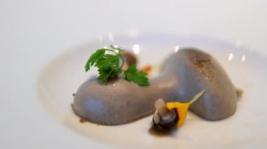 Mantar şeklinde beyaz bir tabakta mantar ezmesi servis eden lüks bir restoran. Kahvaltıda et ezmesini bıçakla mantarla kaplamak. moleküler mutfak.