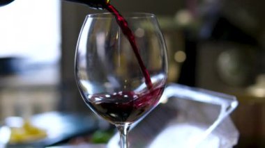 Bir restoranda şarap bardağına kırmızı şarap döküldü. Bir kadeh kırmızı şarap koy.