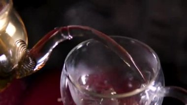 Yeşil, taze demlenmiş sıcak çay, bir bardağa dökülen canlandırıcı bir içecektir. Bir fincana yeşil çay dök.