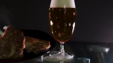 İki bira bardağının yanında sezonluk biftek. bira biftekleri